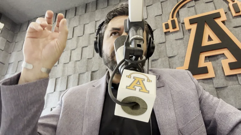 Karloz Vázquez participando en una conversación en estudio de radio